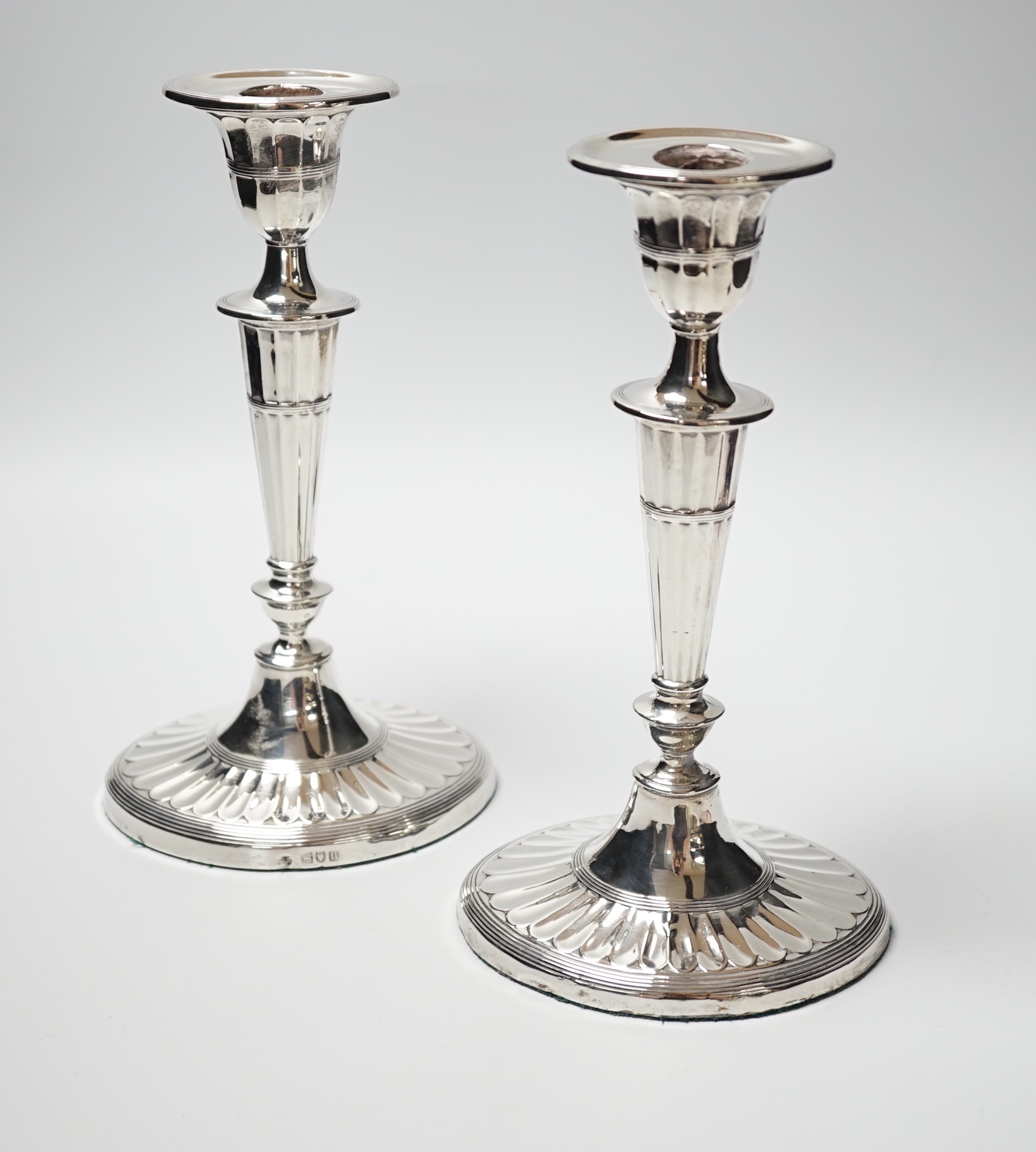 A pair of Edwardian silver candlesticks, with fluted oval bases, William Hutton & Sons Ltd, London, 1907/8, height 21.8cm, weighted.